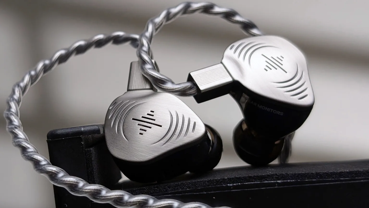 Closeup of Soundbrenner Wave Pro 2 in-ear monitors and braided cable